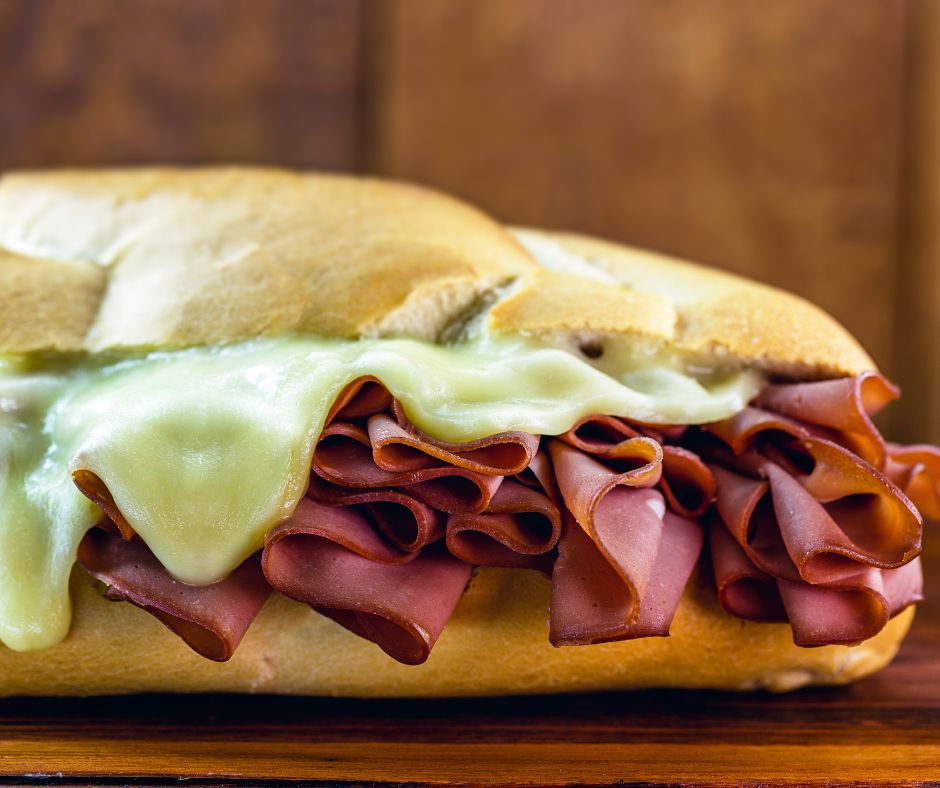 bread with mortadella and melted cheese. Rustic wooden background, São Paulo meal, famous bread and mortadella from São Paulo market.