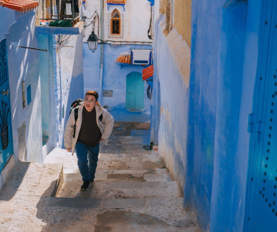 solo traveler walking in alley of Chefchaouen, Morocco