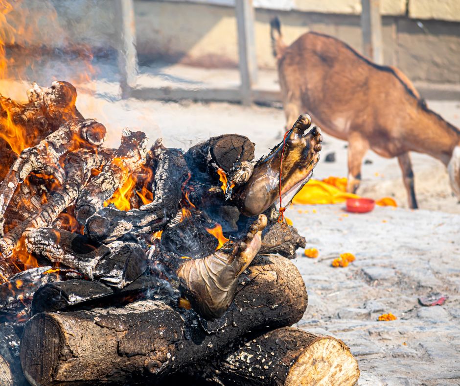 a pyre is burning on harishchandra ghat in banaras